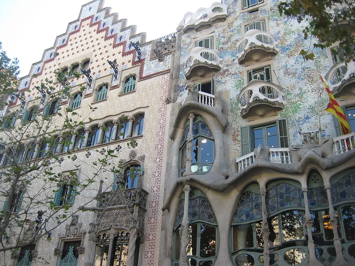 Two neighboring facades on Passeig de Gràcia: the stepped gable of Casa Amatller and the mosaic front and bony balconies of Casa Batlló