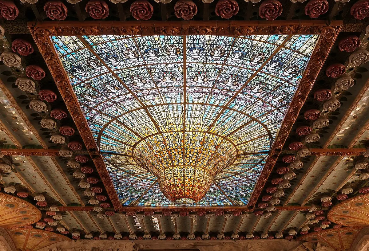 The stained-glass skylight of the Palau de la Música Catalana, a golden upturned dome framed by ceramic roses