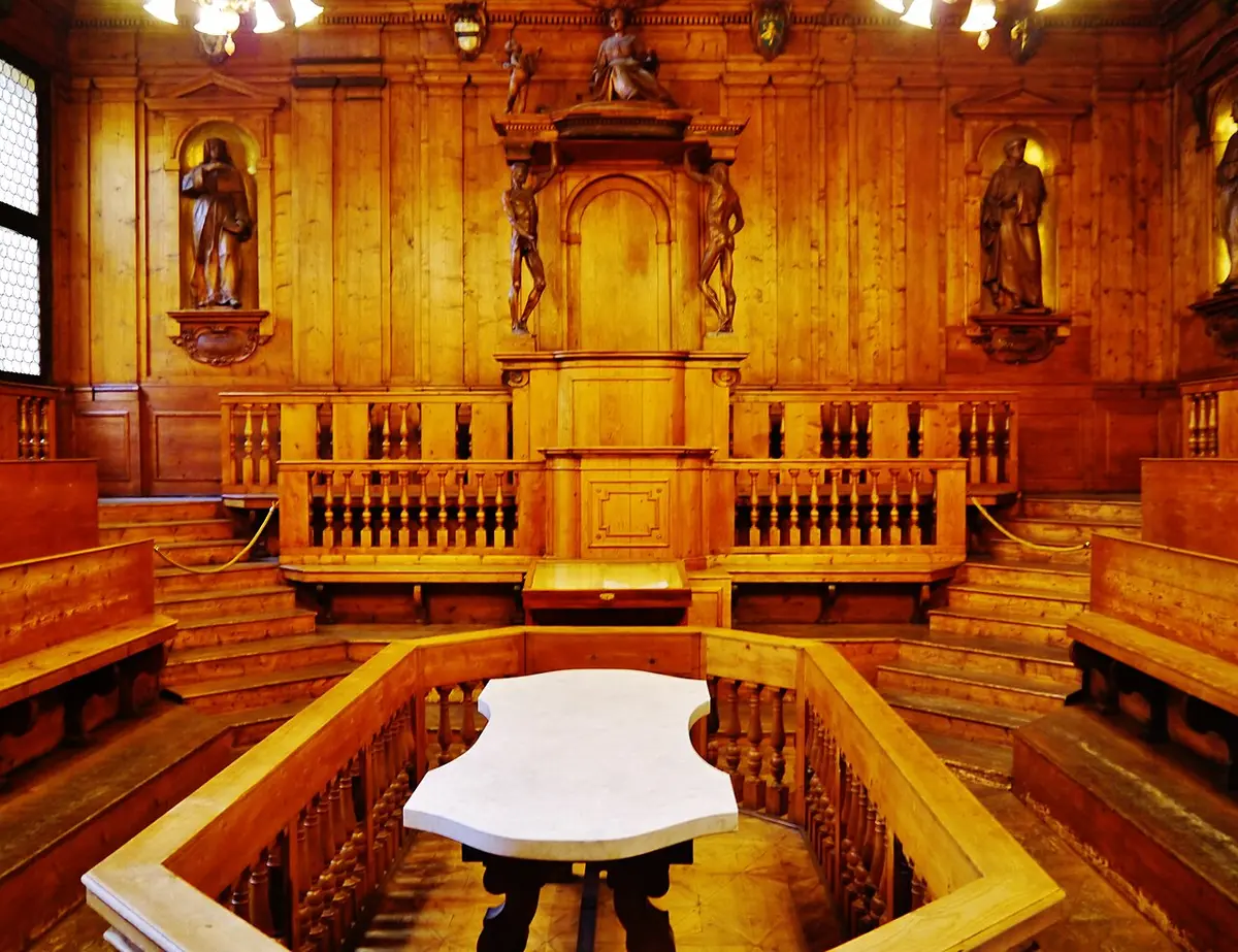 The wood-paneled Anatomical Theatre of the Archiginnasio, a marble table in the middle and carved figures around the walls