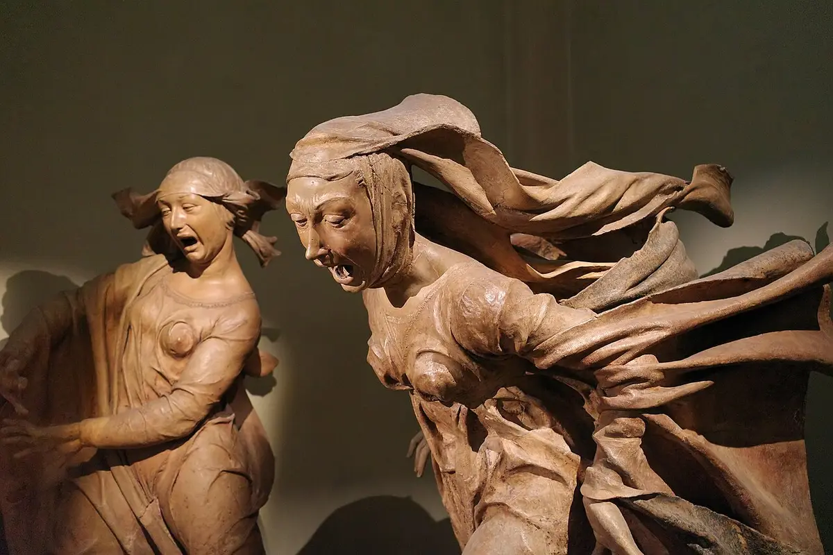 Two terracotta women in grief, mouths open and robes blown back, from Niccolò dell’Arca’s Lamentation