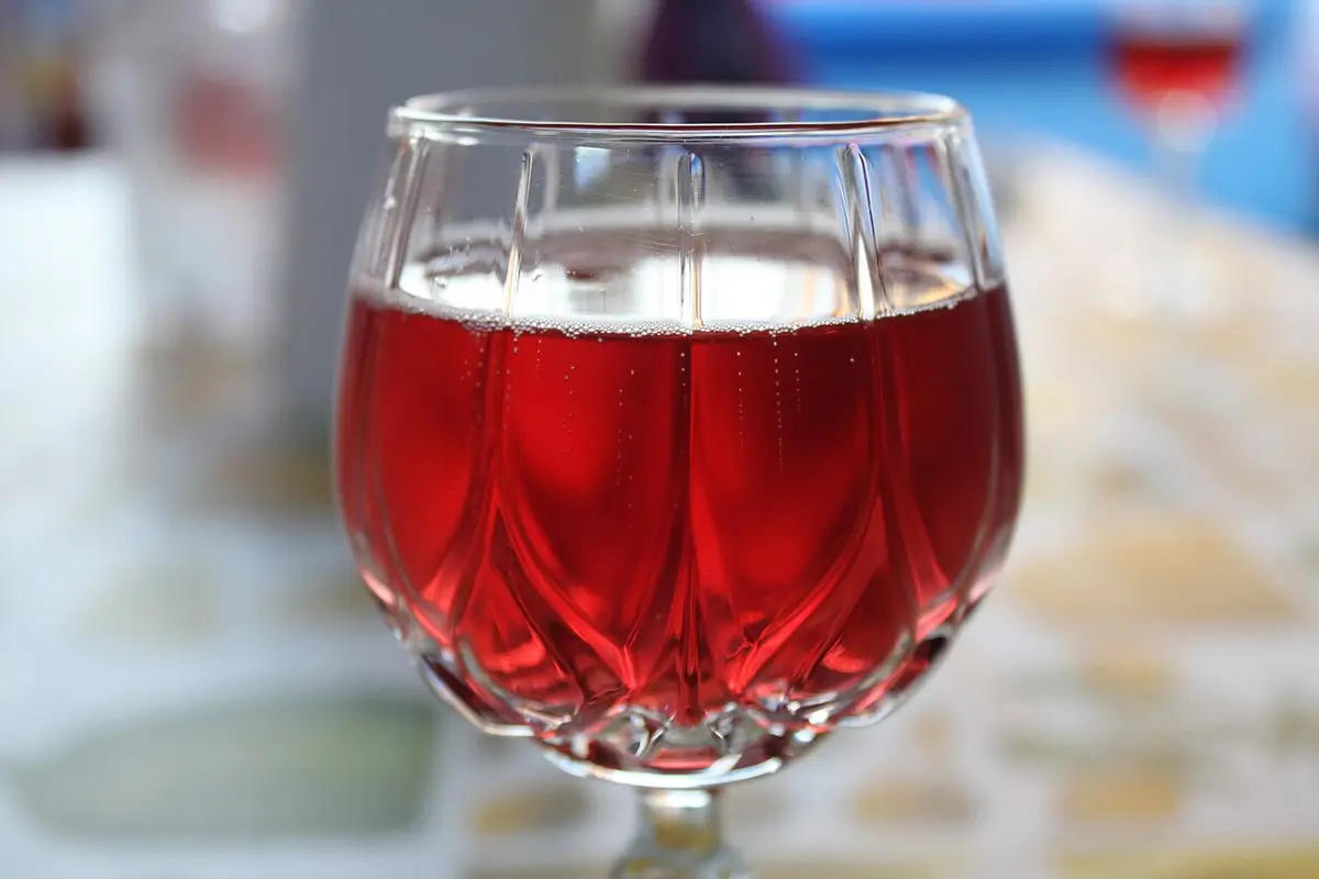 A glass of pale red, lightly sparkling Lambrusco on a table