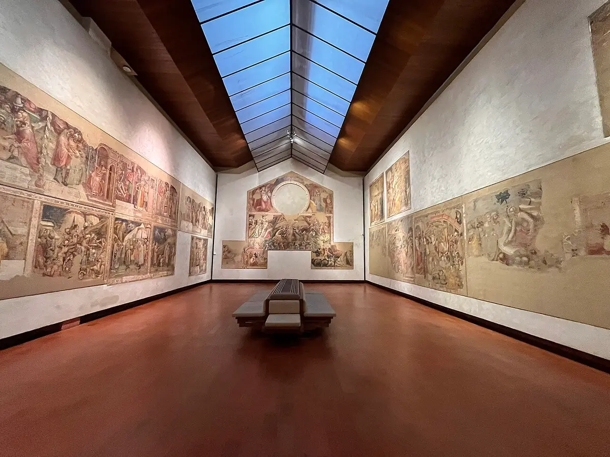 A long gallery of the Pinacoteca Nazionale with detached medieval frescoes on the walls under a skylight