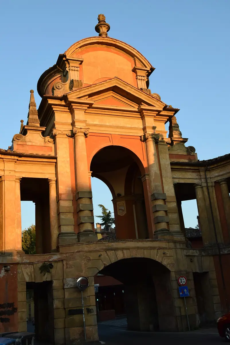 The baroque Arco del Meloncello in warm evening light, the road passing under it