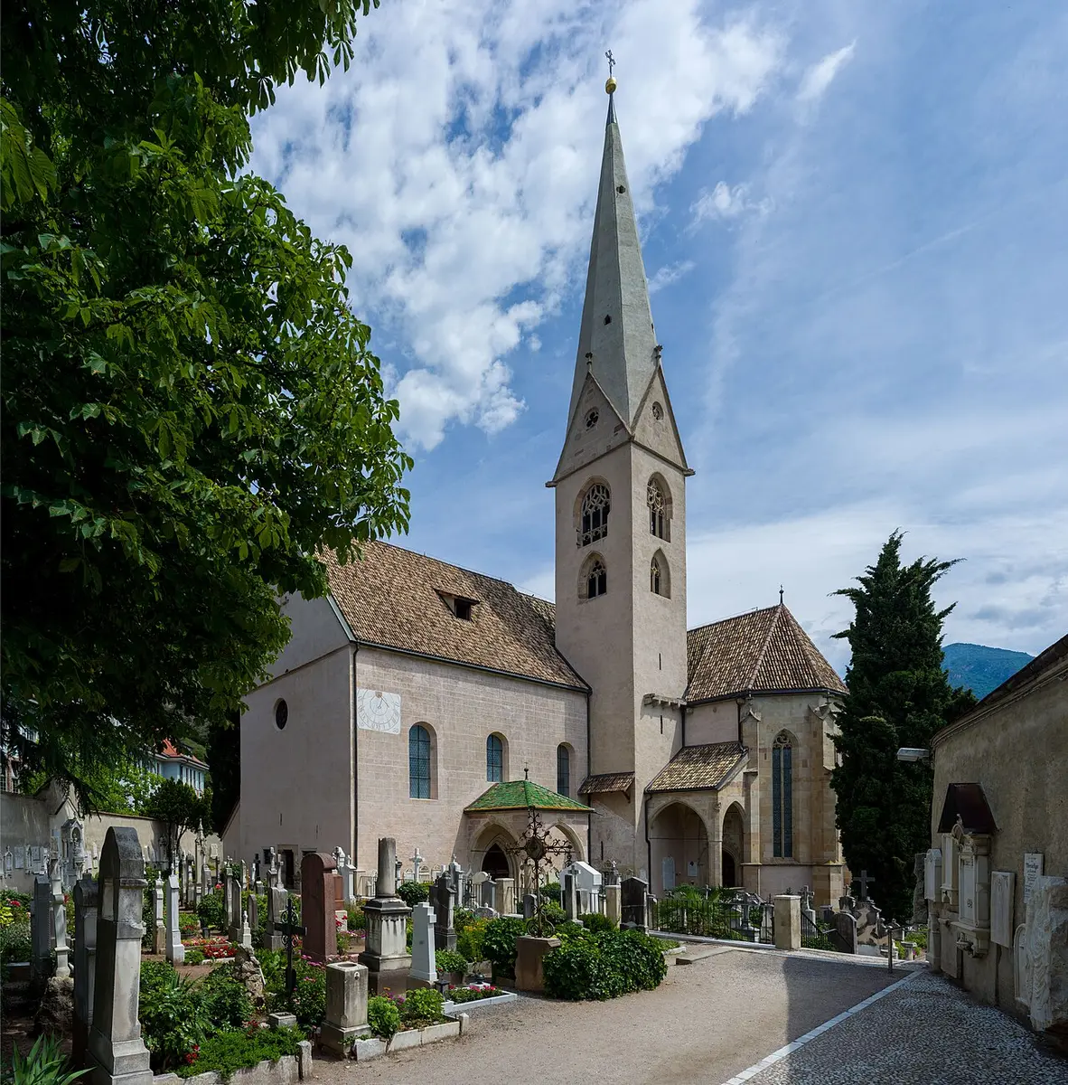 The Old Parish Church of Gries with its tall pointed spire, beyond its churchyard
