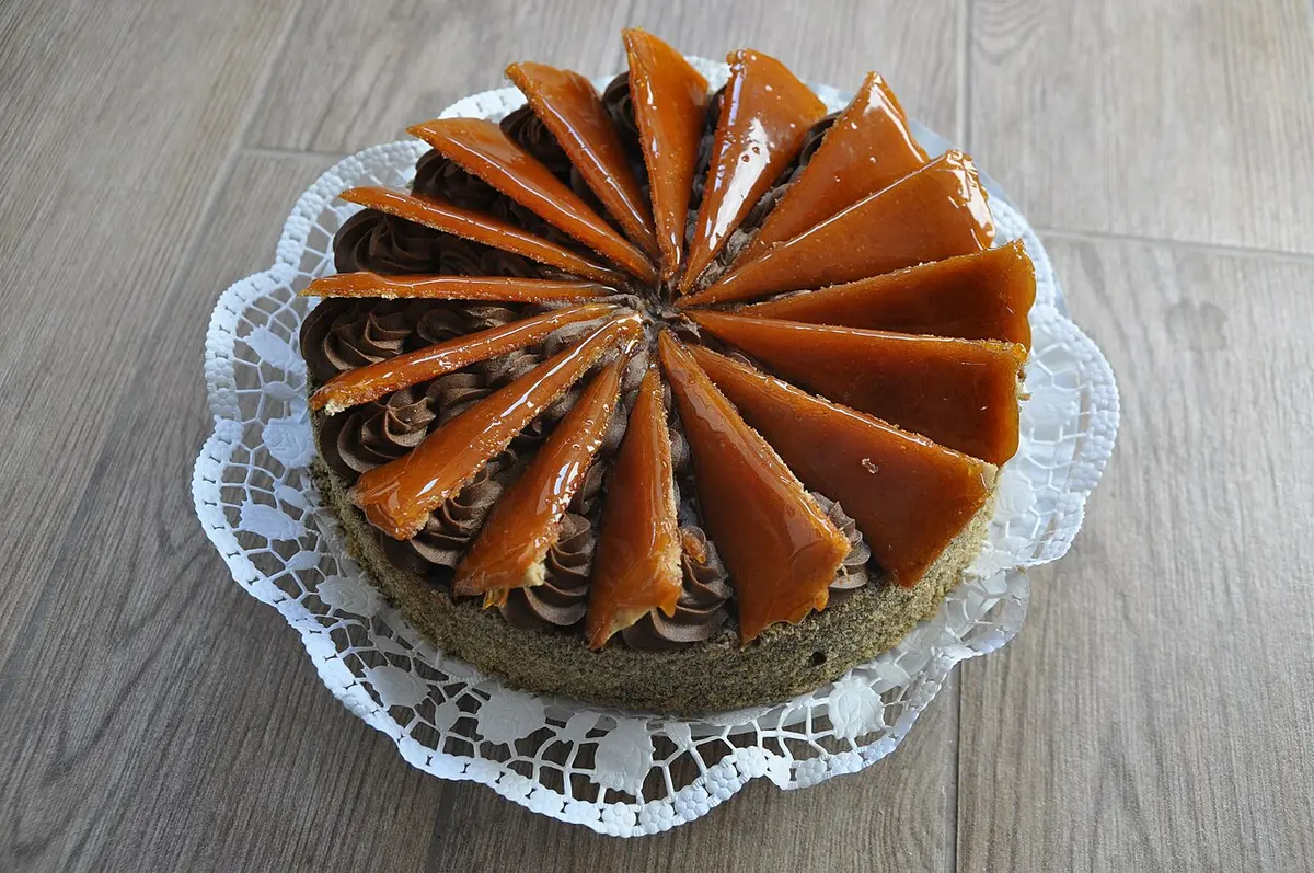 A whole Dobos torte topped with a ring of caramel wedges