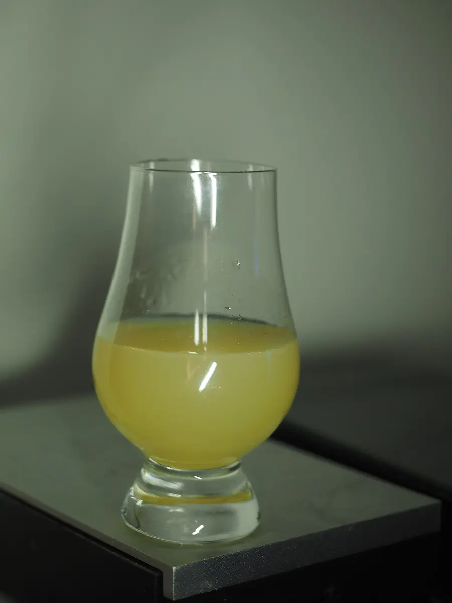 A glass of pastis turned cloudy yellow with water