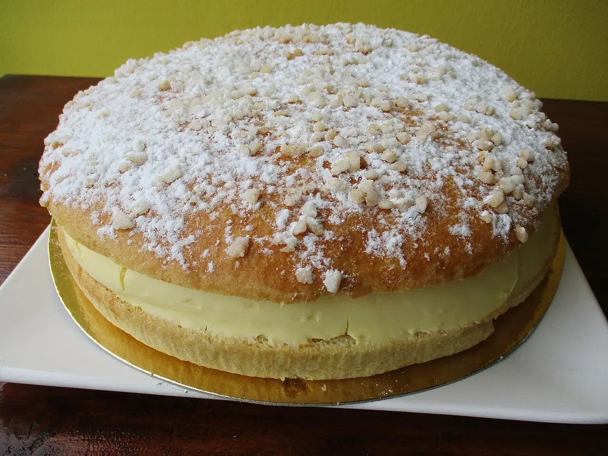 A round tarte tropézienne, a brioche sprinkled with sugar and filled with cream