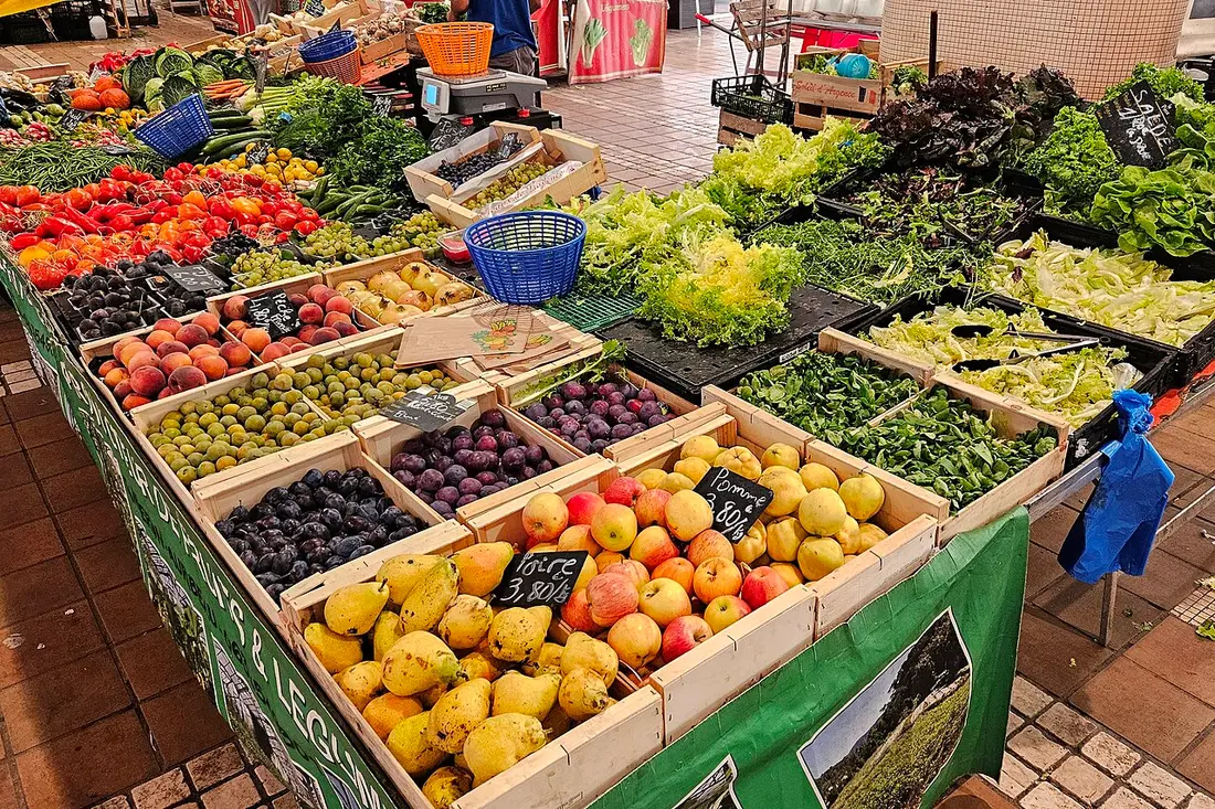 Crates of peaches, plums, pears, salad leaves and tomatoes on a stall in the Marché Forville