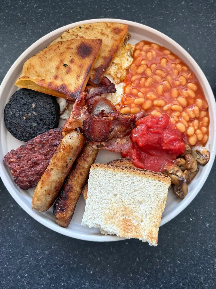 A Scottish breakfast of tattie scones, black pudding, square sausage, link sausages, bacon, egg, beans, tomato, mushrooms and toast