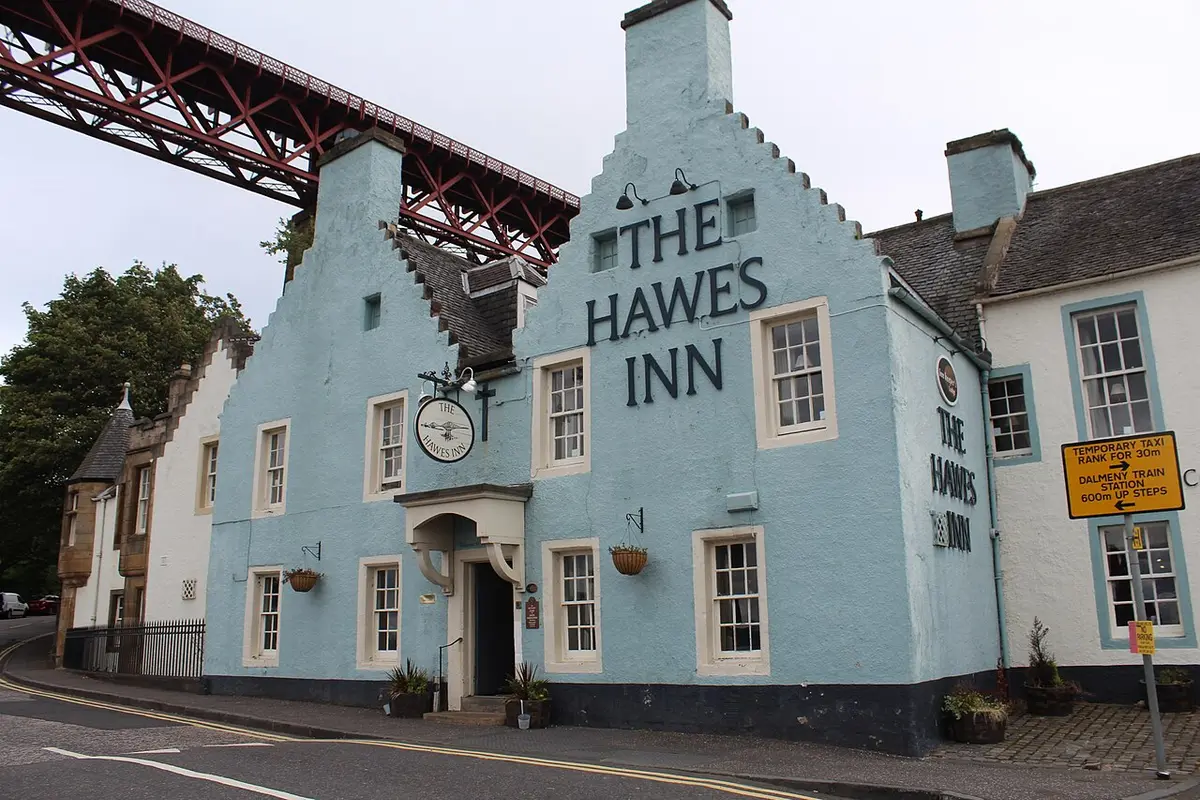 The pale blue Hawes Inn with its crow-stepped gables, the red girders of the Forth Bridge above it