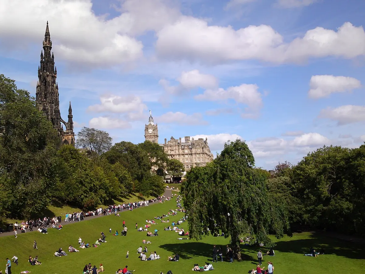 The lawns of East Princes Street Gardens on a sunny day, with the Gothic spire of the Scott Monument on the left