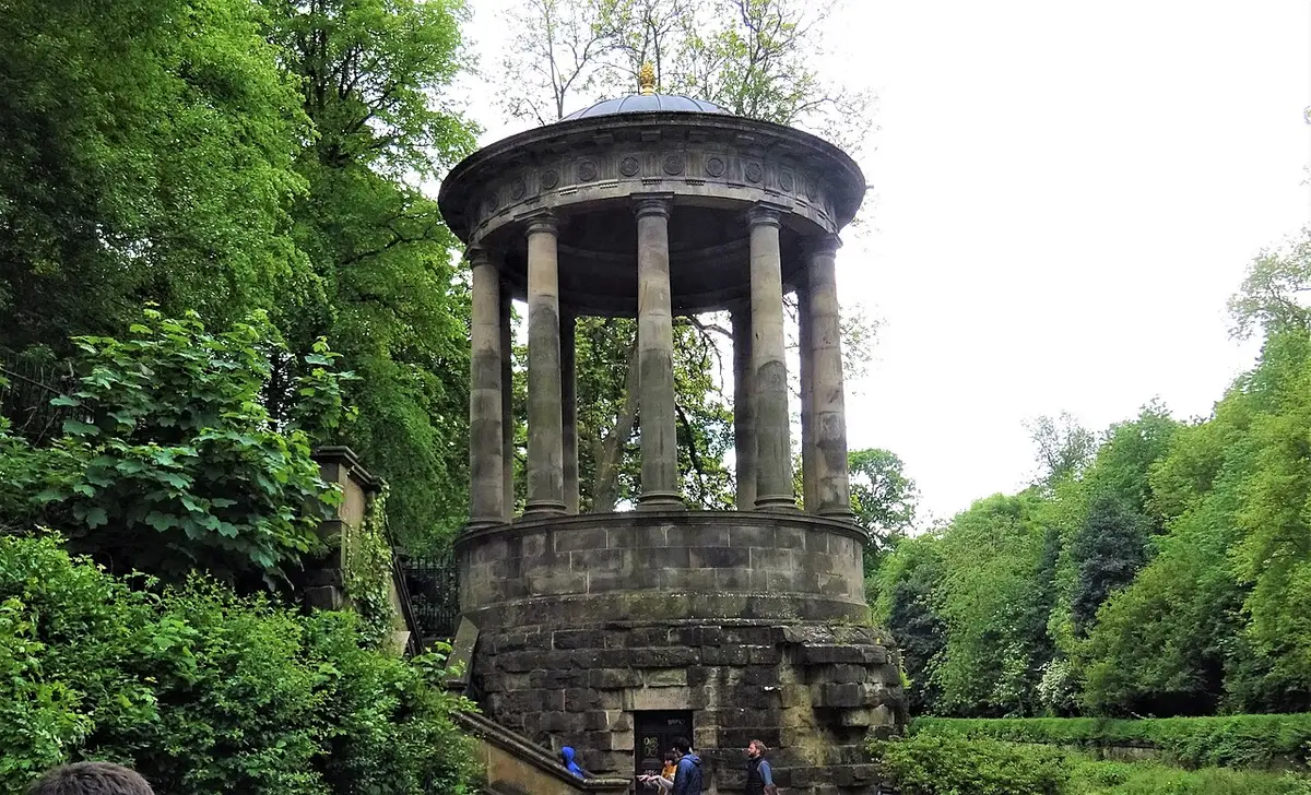 St Bernard’s Well, a round classical temple on a stone base among trees beside the Water of Leith
