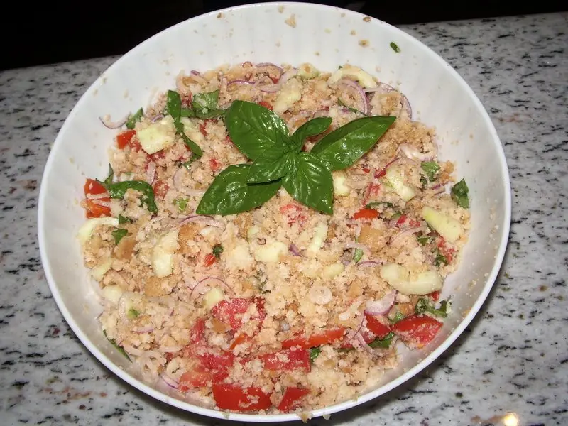 Panzanella, a salad of soaked bread, tomato and basil, in a white bowl