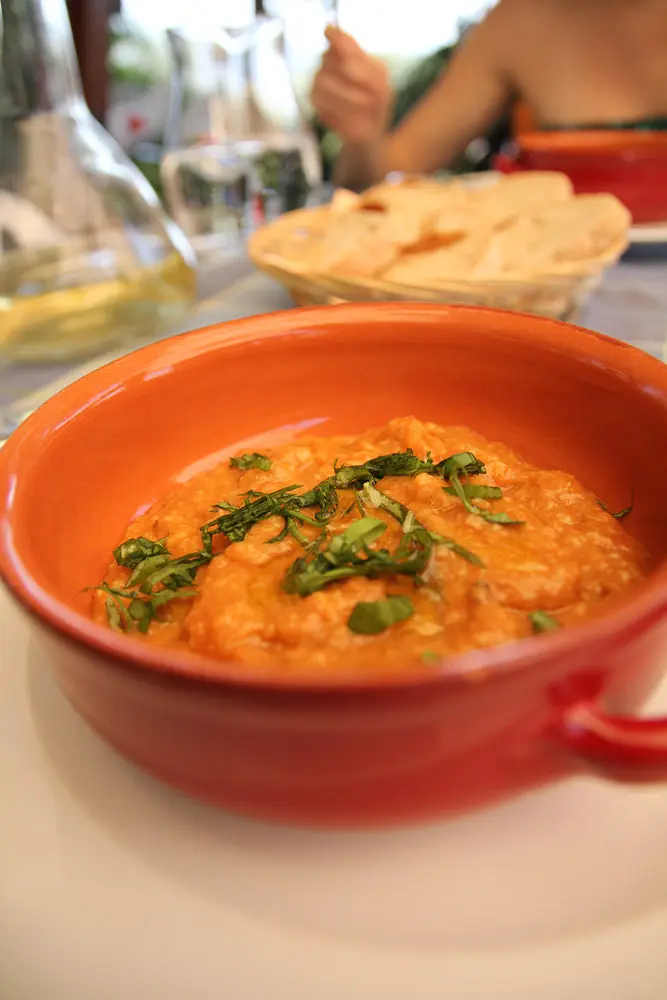 Pappa al pomodoro, a thick bread and tomato soup, in an orange bowl with basil