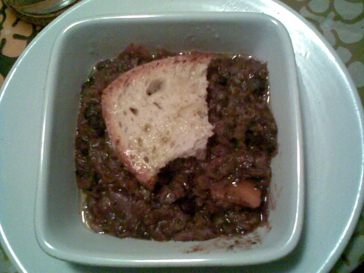 A bowl of ribollita, a thick soup of bread, beans and dark cabbage, with a slice of bread