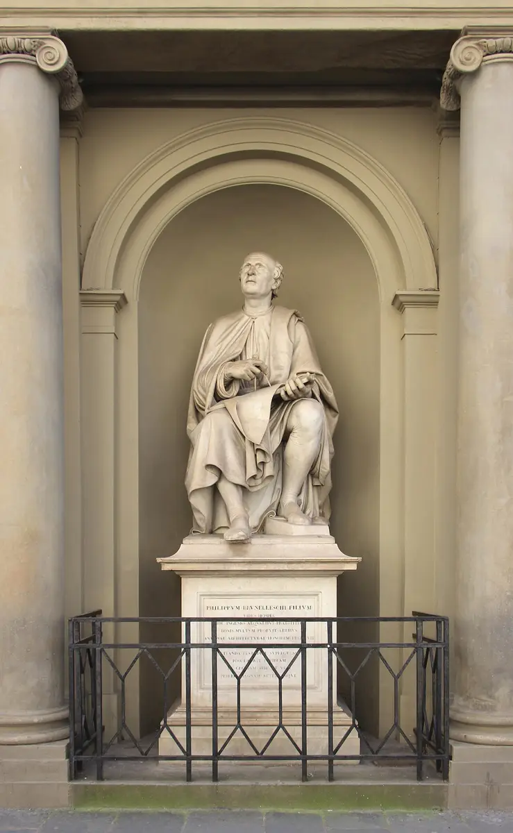 Marble statue of Brunelleschi seated in a niche, looking up, with a drawing of the dome on his knee