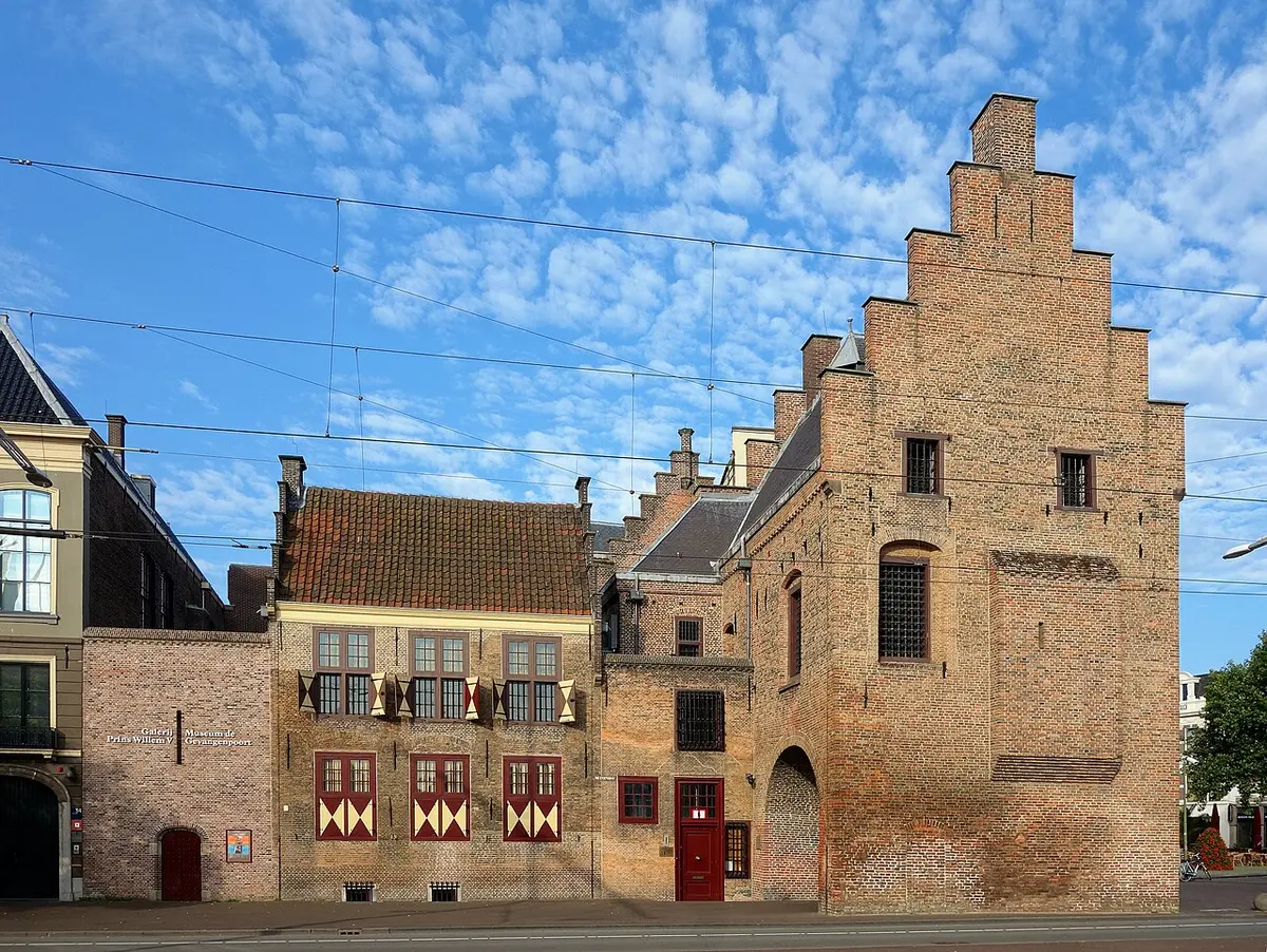 The Gevangenpoort, a medieval brick gatehouse with a stepped gable, under a blue sky