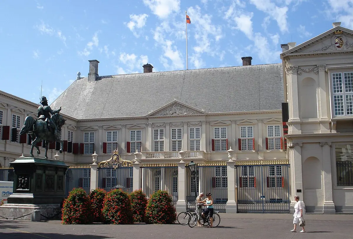 Noordeinde Palace, a pale classical palace with two wings, with an equestrian statue in front