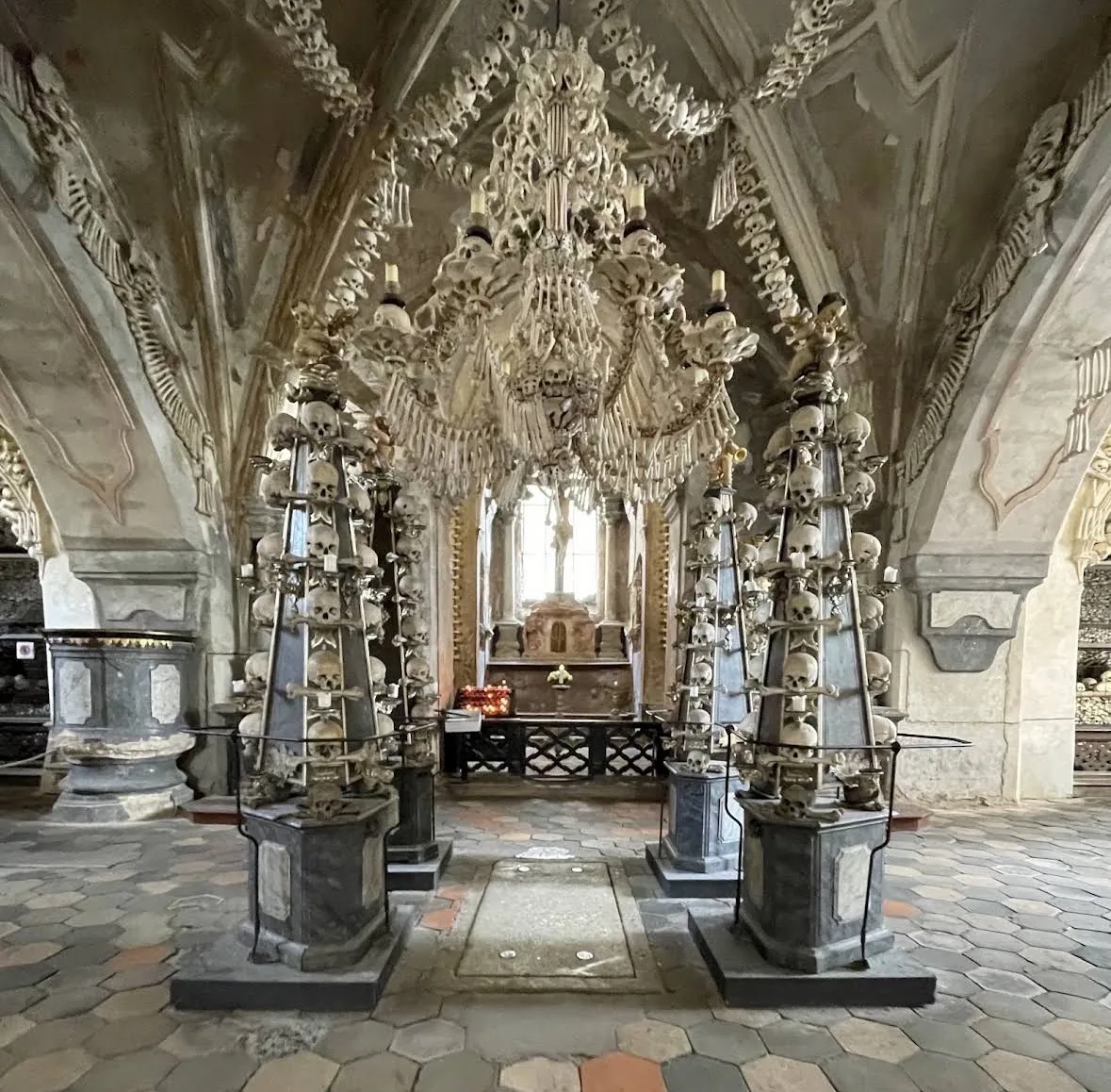 The Sedlec Ossuary’s chandelier of bones and skulls hanging over the nave, between two pyramids of skulls