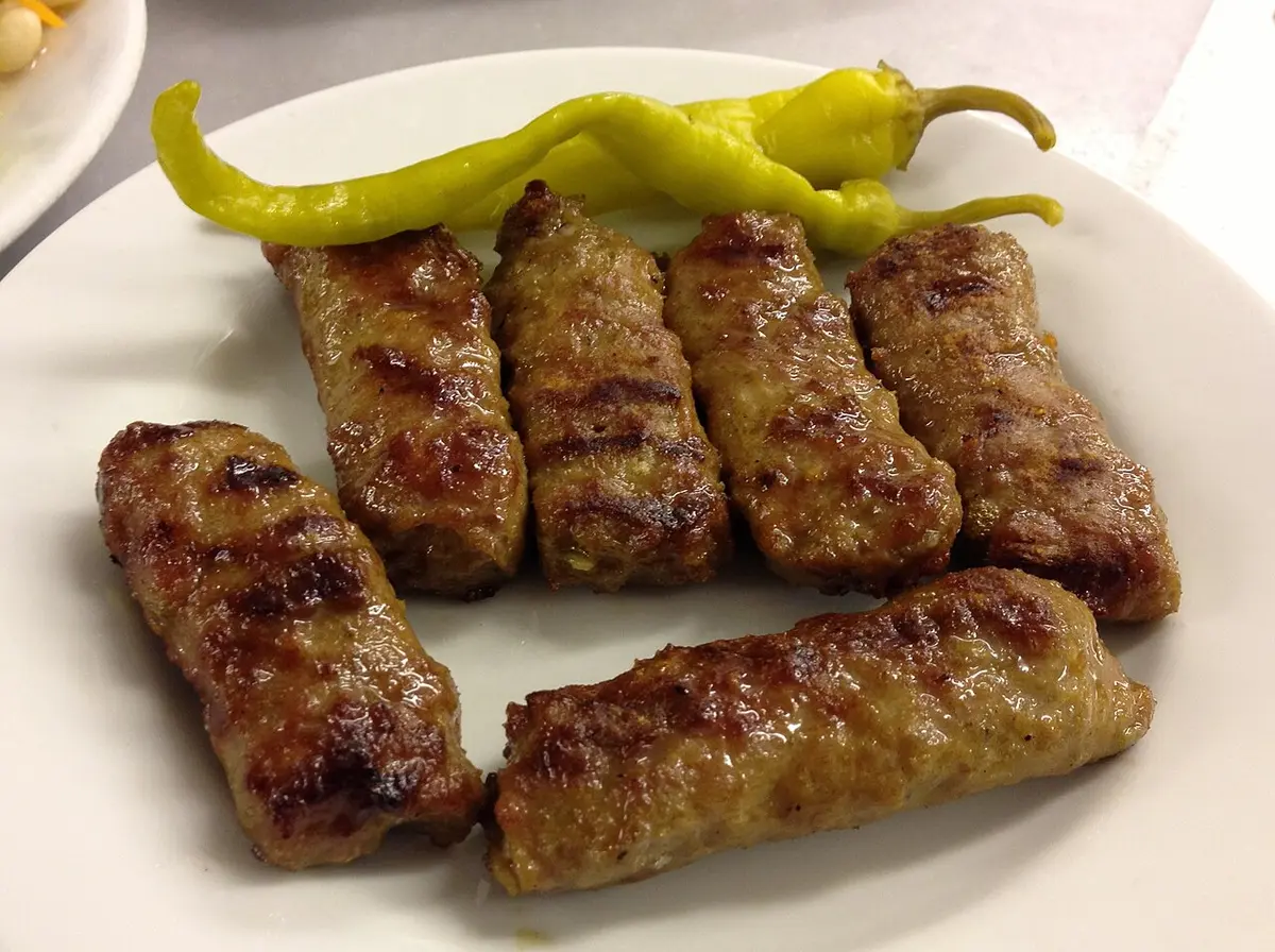 Grilled köfte, small finger-shaped meatballs, with pickled green peppers