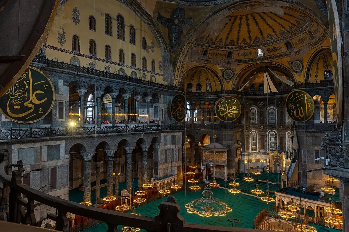 Inside Hagia Sophia, looking down from the upper gallery onto the prayer hall, with round calligraphy panels and the dome above