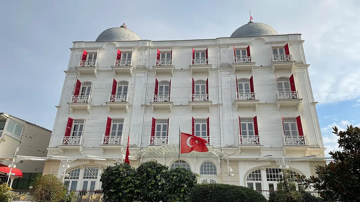 The white Splendid Palas Hotel on Büyükada, with red shutters, two domes and a Turkish flag