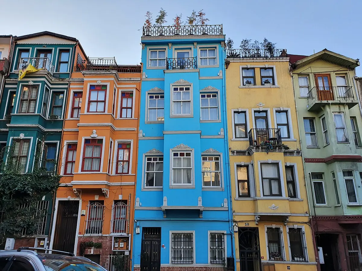 A row of tall houses painted blue, orange, yellow and green in Balat