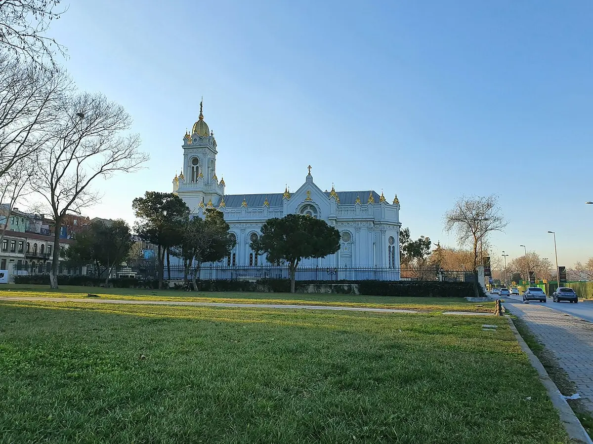 The white Bulgarian St. Stephen Church and its bell tower by the Golden Horn, a lawn in front