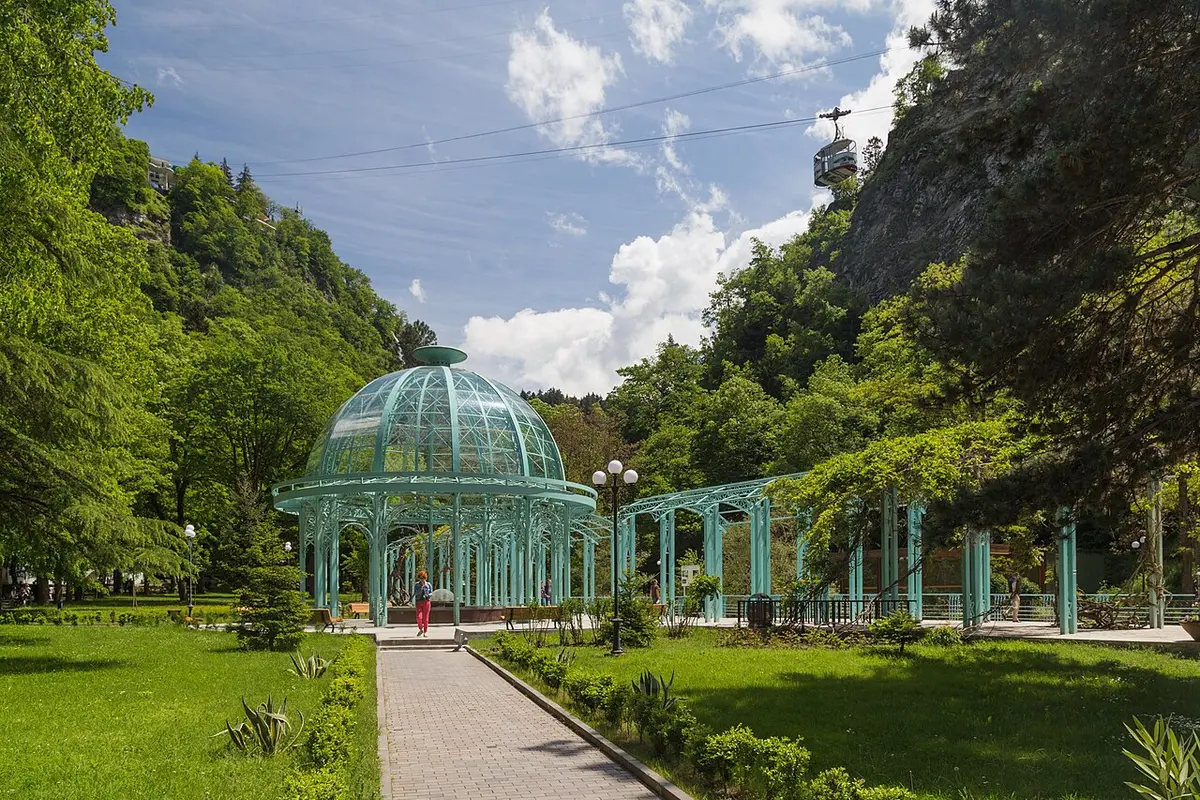 The glass-domed pavilion over the mineral spring in Borjomi’s Central Park, with wooded hills behind