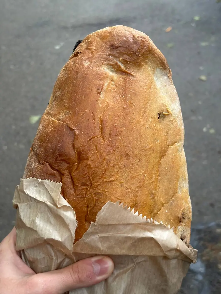A loaf of nazuki, a golden sweet bread, half wrapped in paper