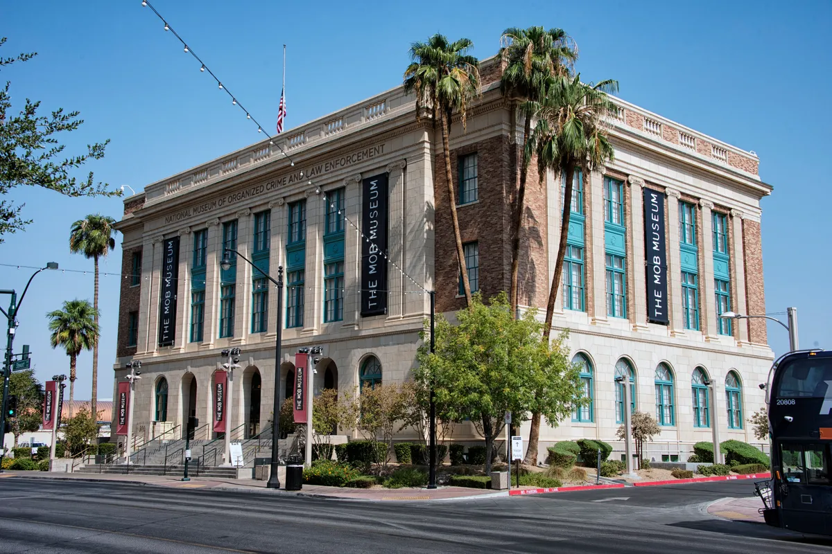 The neoclassical former post office and courthouse on a street corner, Mob Museum banners on its front and palm trees beside it
