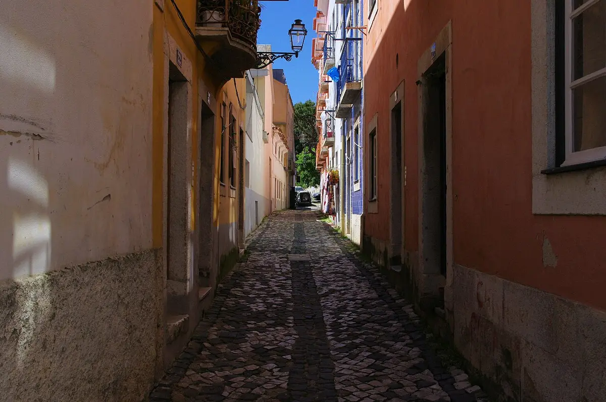 A narrow cobbled lane between old houses in Alfama, Lisbon