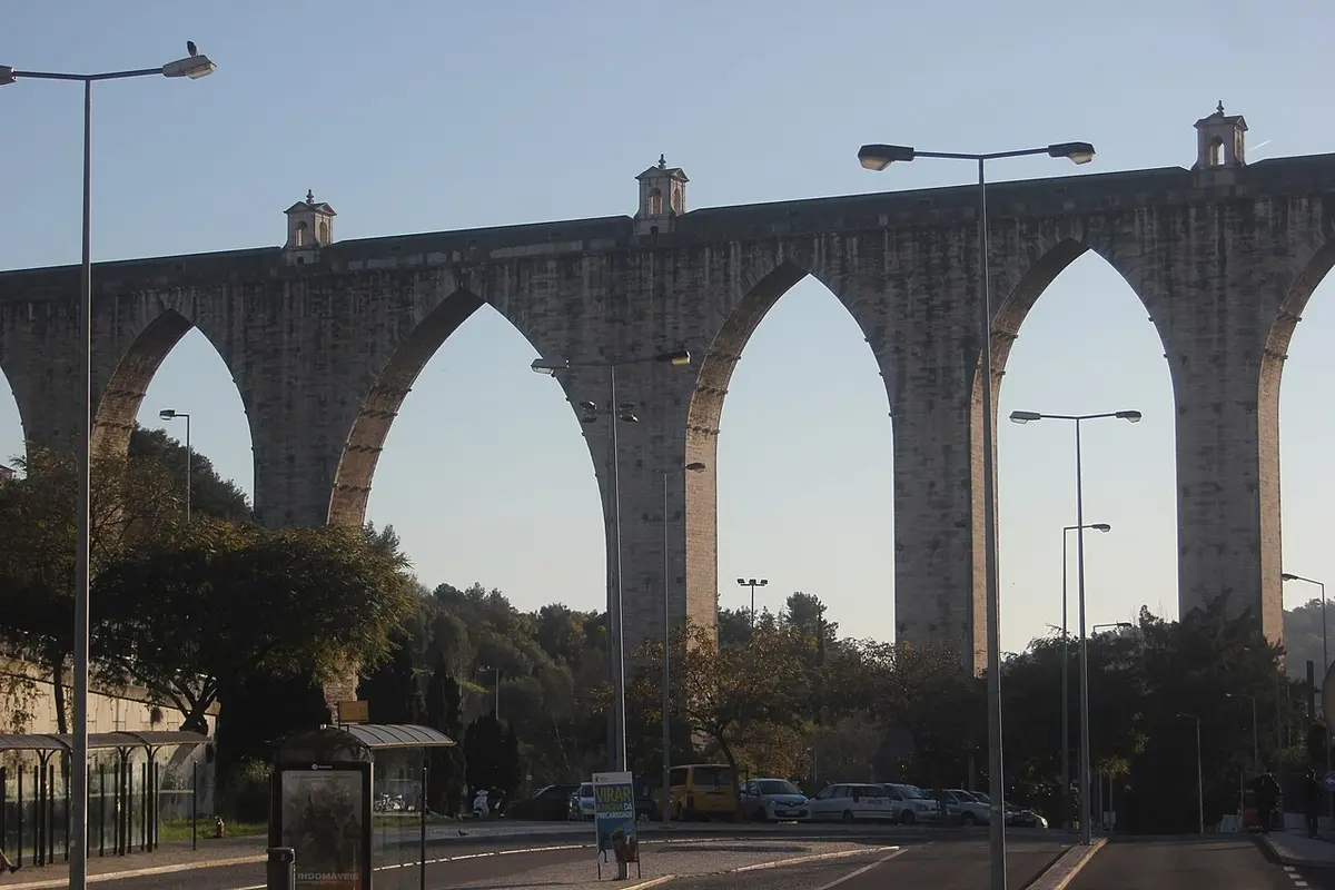 Tall pointed stone arches of the Águas Livres Aqueduct against the sky