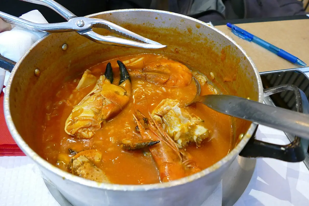 A pot of arroz de marisco, seafood rice with crab in a tomato broth