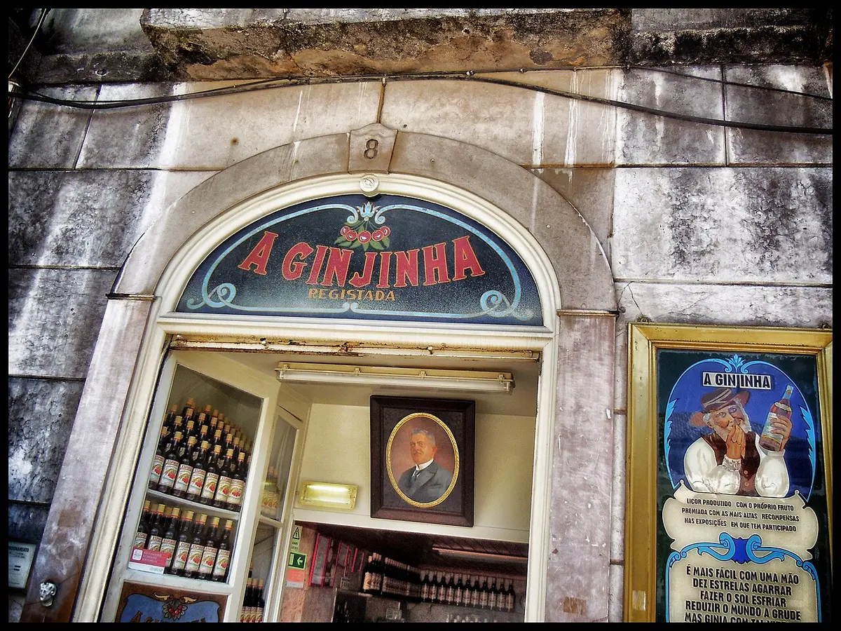 The shopfront of A Ginjinha, a tiny bar with bottles behind the counter