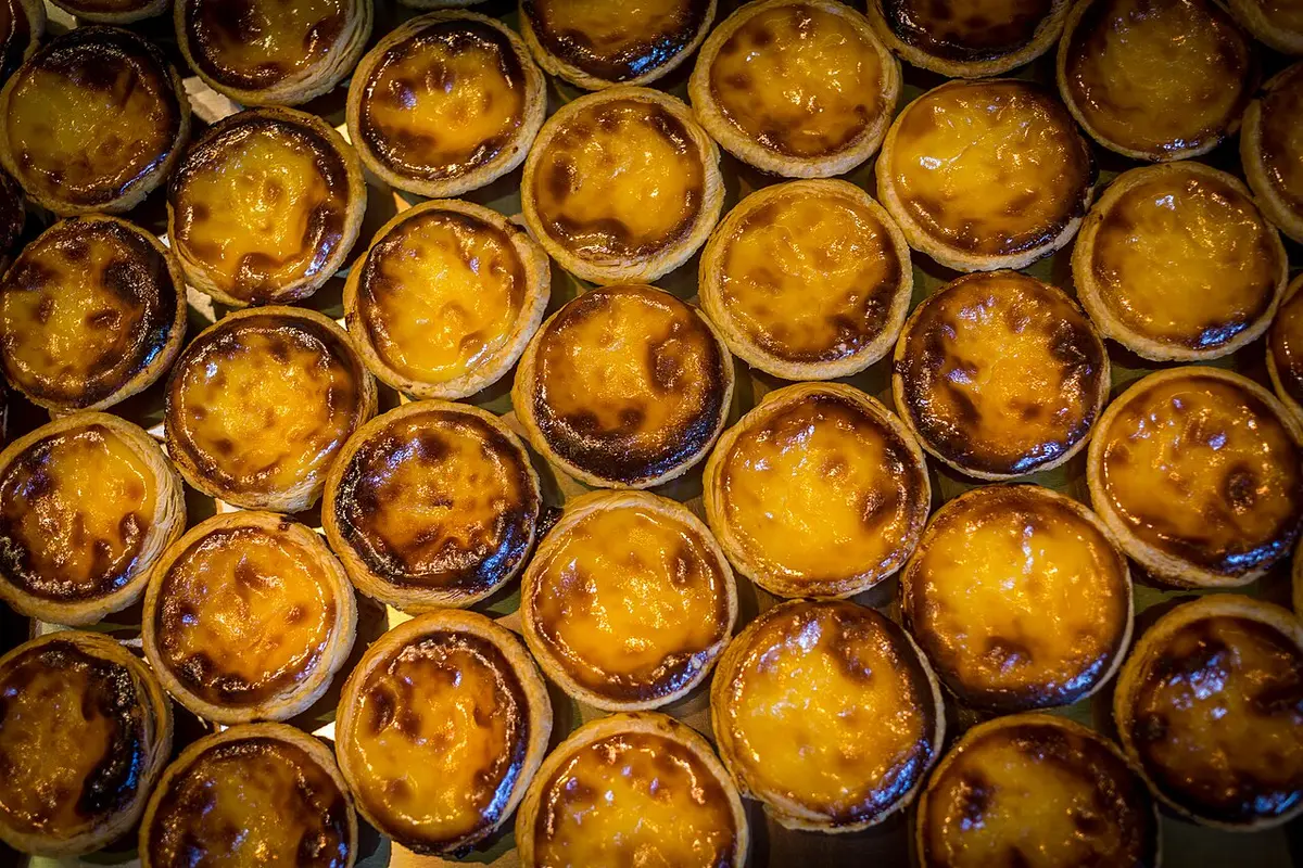A tray of pastéis de nata with scorched tops