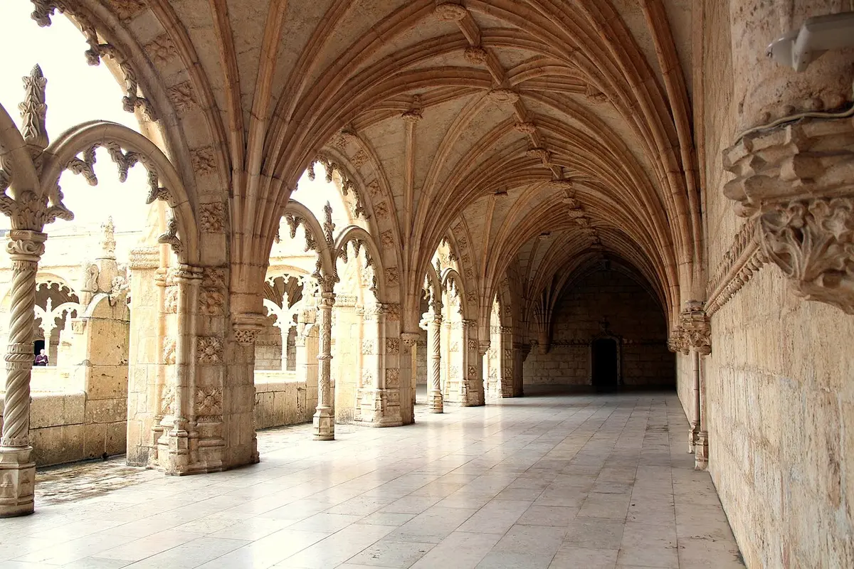 The carved stone arcades of the Jerónimos Monastery cloister in warm light