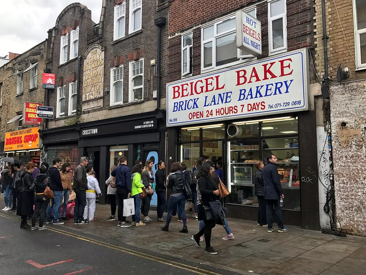 The Beigel Bake shopfront on Brick Lane with a line of customers outside
