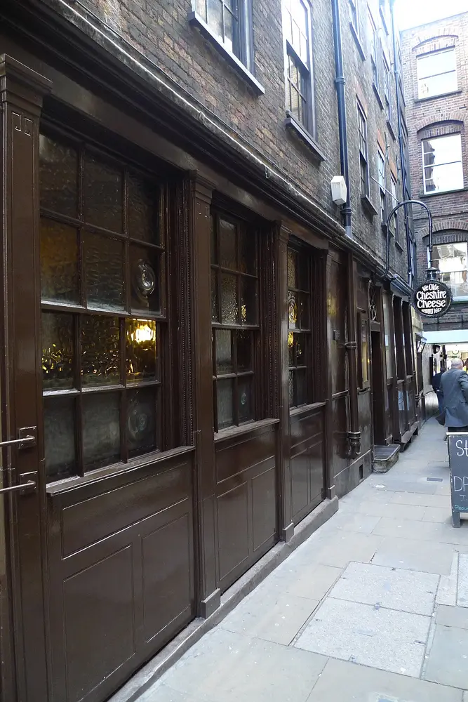 The dark wooden front of Ye Olde Cheshire Cheese pub in a narrow court