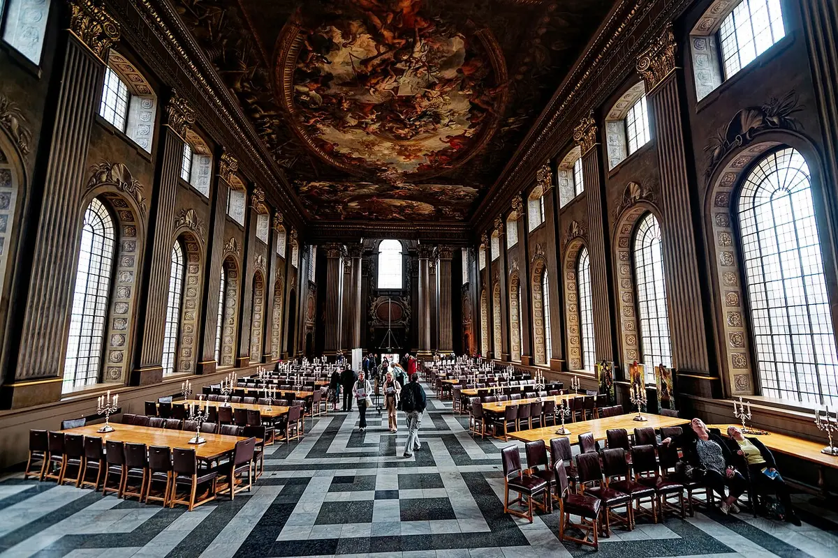 The long Painted Hall with painted walls and ceiling above a black and white marble floor and dining tables