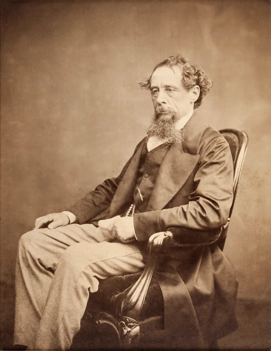 Sepia photograph of Charles Dickens seated in a chair