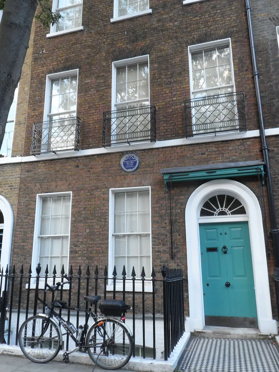 The brick front of 48 Doughty Street with a blue plaque and a green door