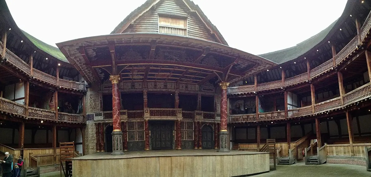 The painted stage and timber galleries of Shakespeare’s Globe around an open yard