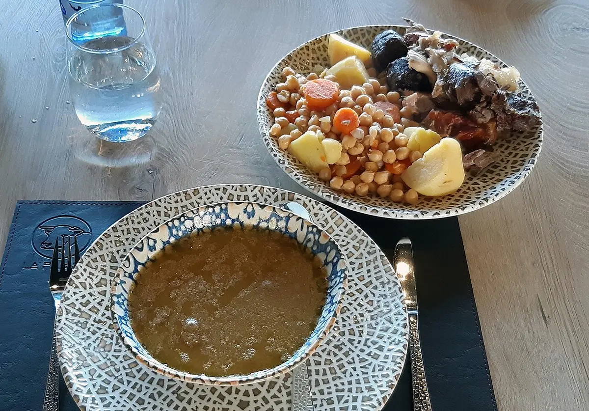 Cocido madrileño in two courses: a bowl of broth and a plate of chickpeas, vegetables and meats