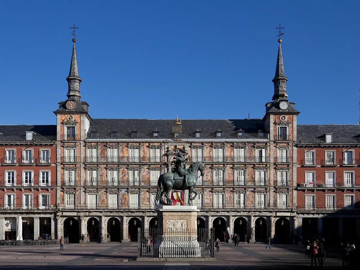 The painted Casa de la Panadería on Plaza Mayor, with the equestrian statue of Philip III in front