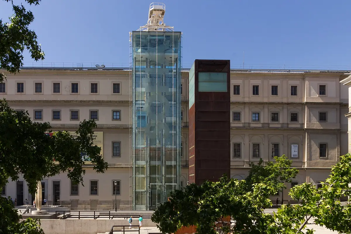 The Sabatini building of the Reina Sofía museum, a long 18th-century hospital front with a modern glass lift tower