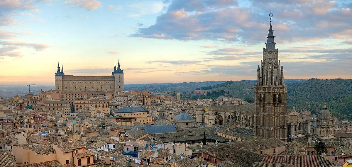 The rooftops of Toledo at sunset, the Alcázar on the left and the cathedral’s spire on the right