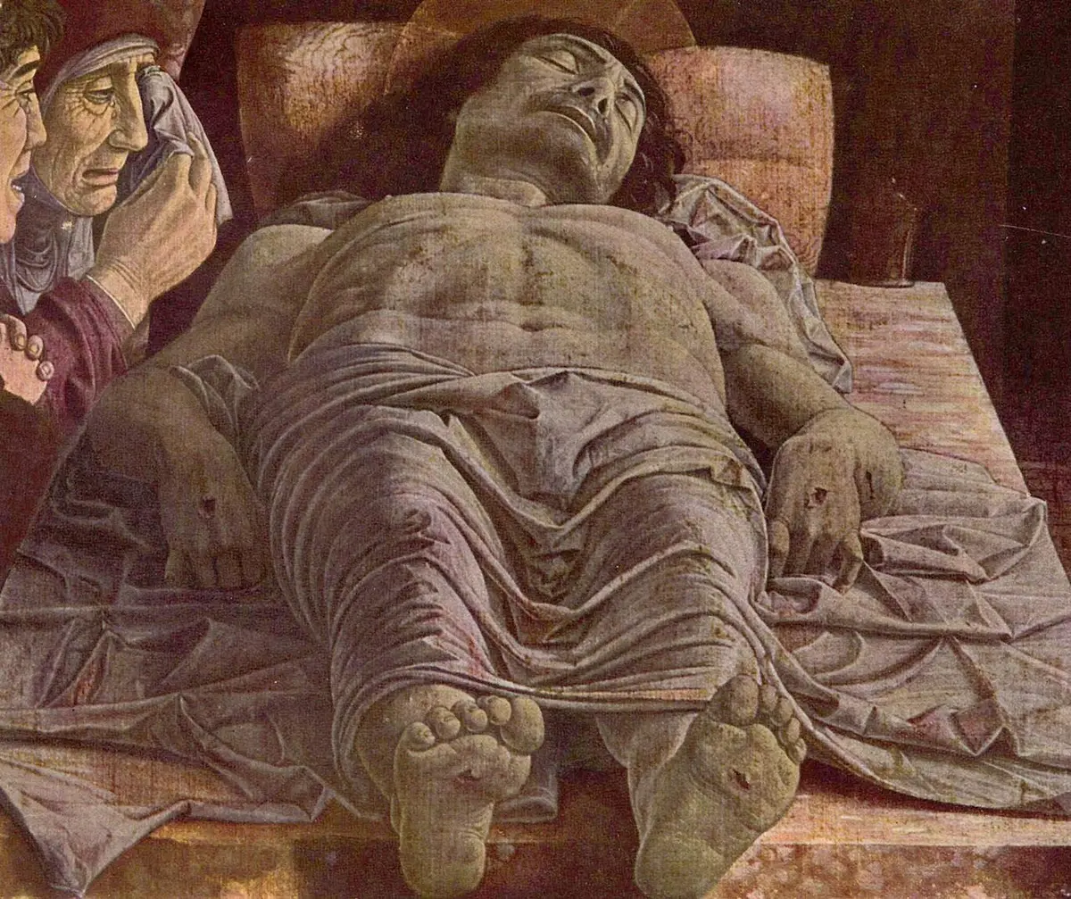 Mantegna painting of the dead Christ seen feet first on a stone slab, mourners at the side