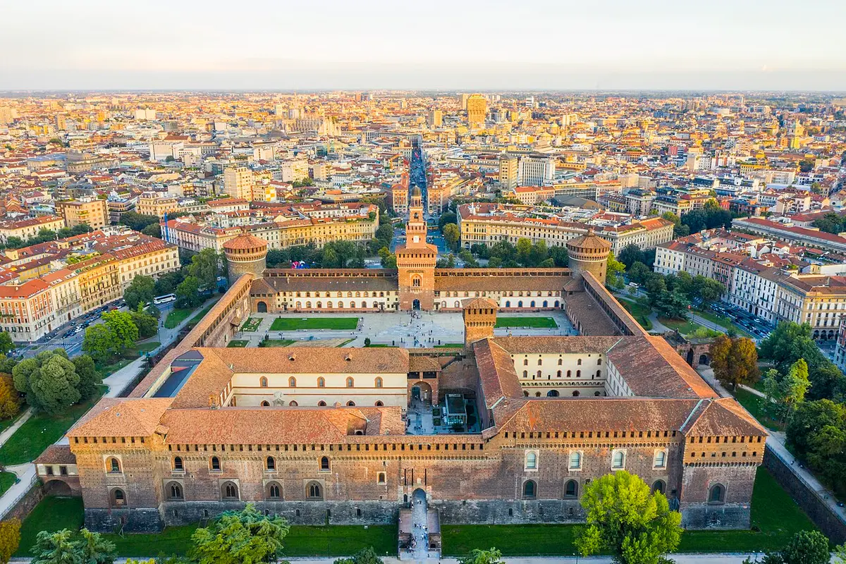 The Sforzesco Castle from above, with its courtyards, round corner towers and central gate tower, the city beyond
