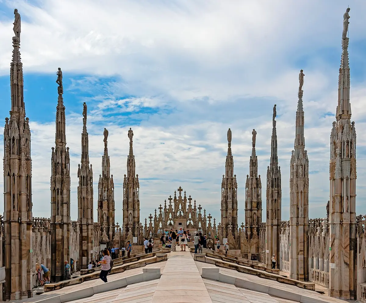 Rows of marble spires topped with statues along the walkway on the roof of the Duomo